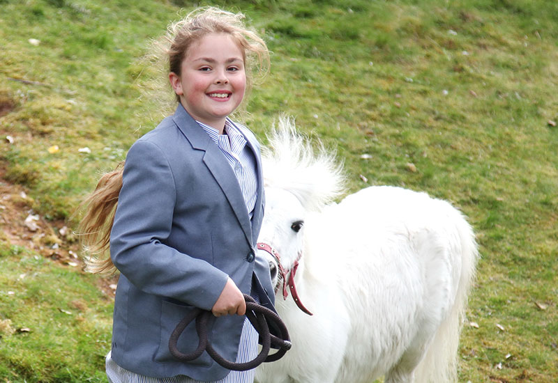 Stafford Grammar Prep pupil running outside with white pony